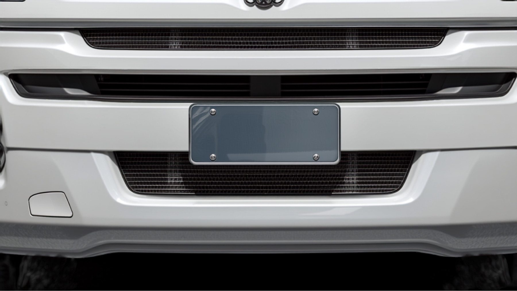 A blank registration plate bracket on the front bumper of a truck